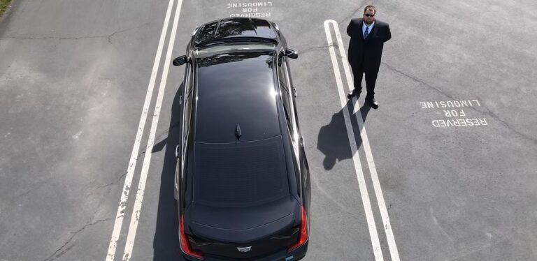 Elegant black limousine parked in Sacramento parking lot with chauffeur.