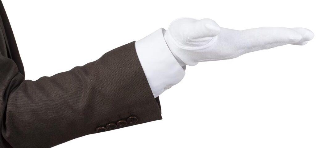 Businessman in suit with outstretched hand for greeting or presentation.
